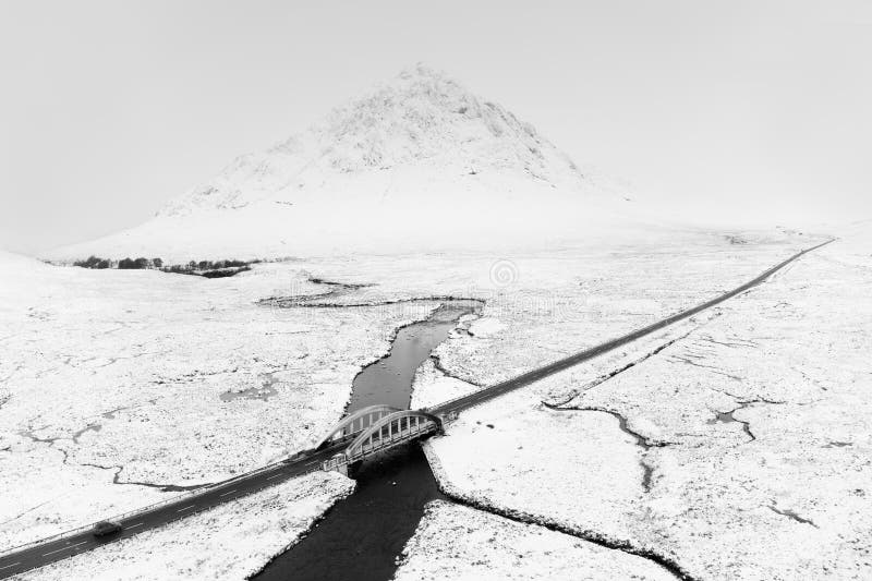 Buachaille Etive Mor mountain and empty road covered in snow during winter