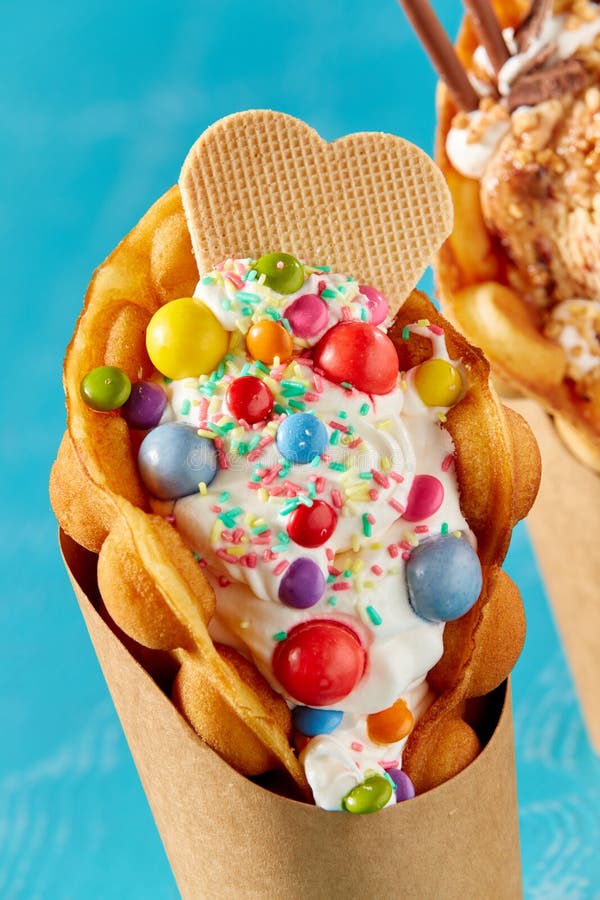 Bubble Waffle Ice Cream with Chocolate Candies and Sticks on a Blue
