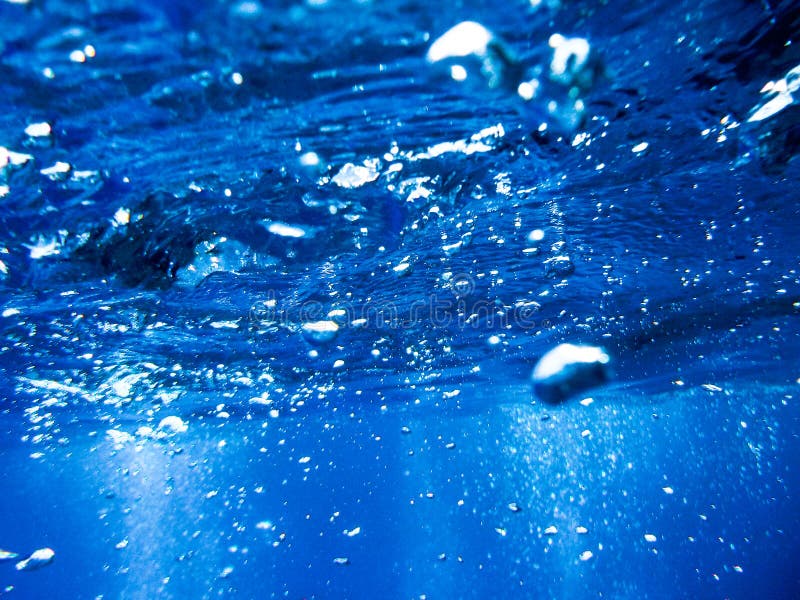 Bubbles from a Scuba diver rising to the surface in the blue sea