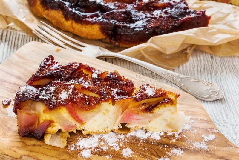 Bucată de tort de mere caramelizate de casă pe fond de lemn. înveliș de zahăr pentru givraj stock photography