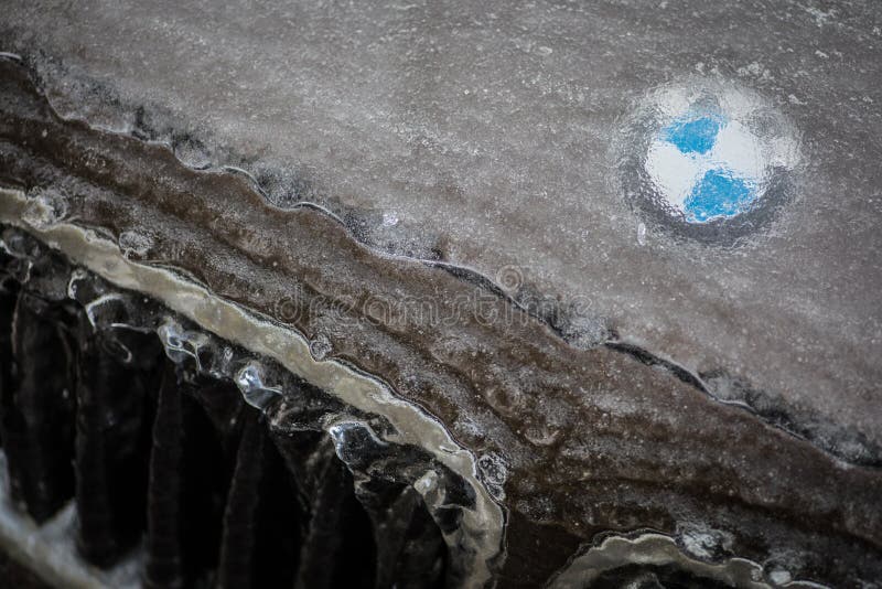 Логотип BMW на капоте автомобиля, покрытый льдом. Бухарест, Румыния-27 января 2019 года: иллюстративно-редакционное изображение логотипа BMW отображается на капоте автомобиля, покрытом стоковой фотографией без роялти
