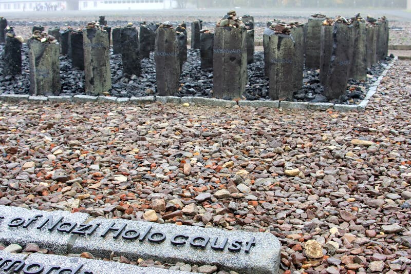 Black basalt steles on a small elevation form the memorial to the Sinti and Romani victims at the site of Block 14, the so-called gypsy block at a sad, rainy day. The steles bear the names of other concentration and extermination camps. Black basalt steles on a small elevation form the memorial to the Sinti and Romani victims at the site of Block 14, the so-called gypsy block at a sad, rainy day. The steles bear the names of other concentration and extermination camps.