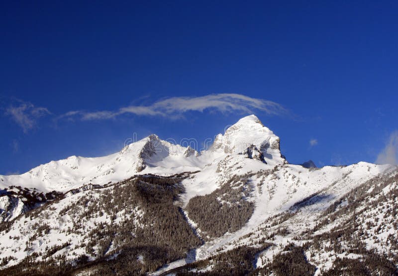 Buck Mountain met wispy cirruswolk die boven in de Bergketen van Grand Teton in het Grote Nationale Park van Tetons in Wyoming bl royalty-vrije stock afbeeldingen Buck Mountain met wispy cirruswolk die boven in de Bergketen van Grand Teton in het Grote Nationale Park van Tetons in Wyoming bl royalty-vrije stock afbeeldingen