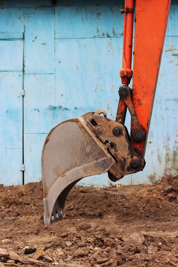 Bucket of an Old Excavator Working on a Parking Lot on a Day Off. Stock