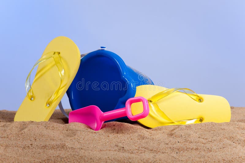 Bucket, shovel and flipflops on the beach