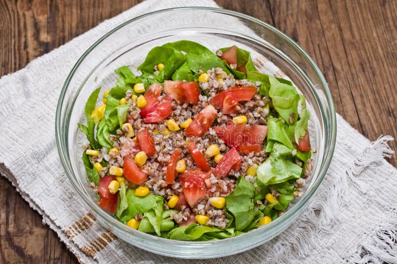 Buckwheat salad for fitness. A glass bowl with buckwheat salad for fitness (buckwheat, lettuce, tomatoes, sweet corn, olive oil, salt royalty free stock photography Buckwheat salad for fitness. A glass bowl with buckwheat salad for fitness (buckwheat, lettuce, tomatoes, sweet corn, olive oil, salt royalty free stock photography