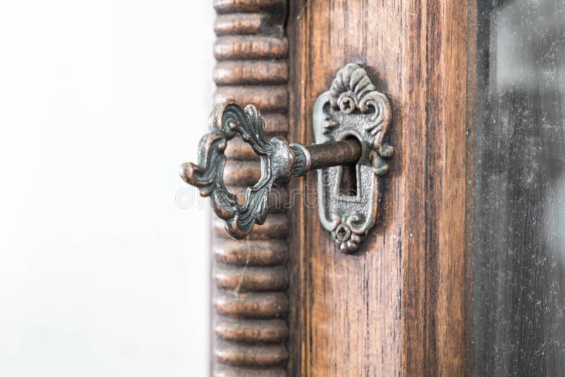 Buco della serratura d'annata con la chiave sul gabinetto di legno d'annata con spazio bianco fotografia stock libera da diritti Buco della serratura d'annata con la chiave sul gabinetto di legno d'annata con spazio bianco fotografia stock libera da diritti