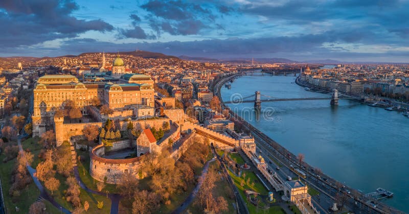 Budapest, Hungary - Aerial panoramic view of Buda Castle Royal Palace with Szechenyi Chain Bridge, Parliament. And colorful clouds at sunrise stock images Budapest, Hungary - Aerial panoramic view of Buda Castle Royal Palace with Szechenyi Chain Bridge, Parliament. And colorful clouds at sunrise stock images