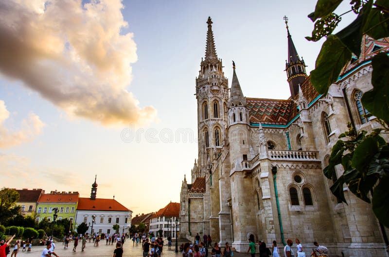 Budapest, Hungary - August 16, 2018: Matthias Church in Budapest and the main square of the Buda Castle area crowded with tourists at sunset