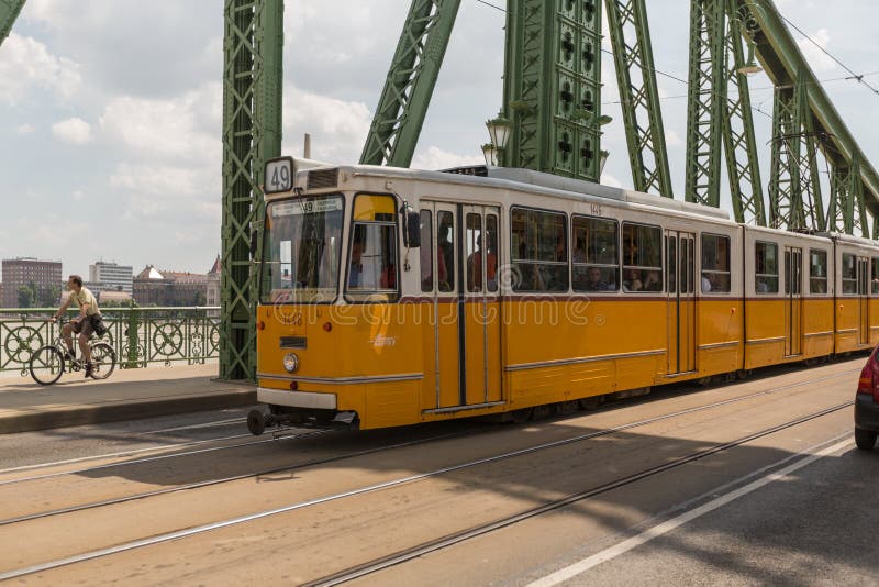BUDAPEST, HUNGARY - JUNE 10, 2014 - The tram on the Liberty bridge with Old Market Hall on the background, on June 10, 2014 in Bud