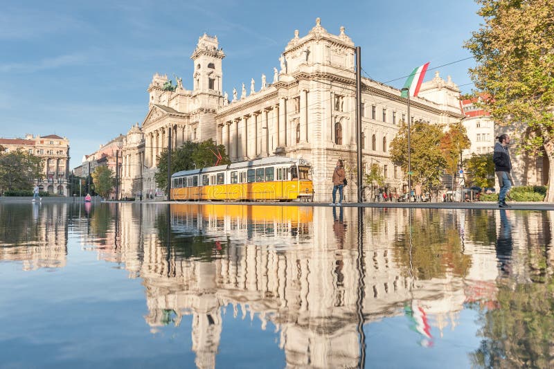 BUDAPEST, HUNGARY - OCTOBER 27, 2015: Budapest Parliament Square with Fountain water, moving tram and reflection.