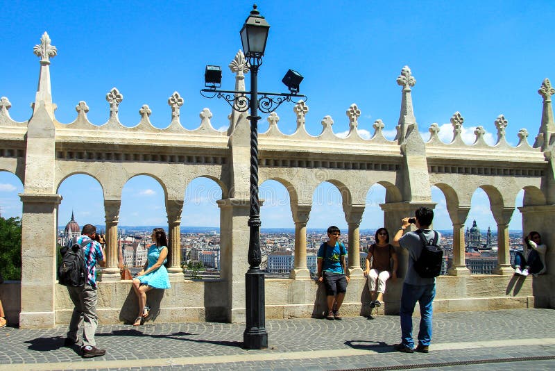 Budapest, Hungary. Tourists looking Parliament view through Fishermans Bastion and take pictures on the Buda Hill stock image Budapest, Hungary. Tourists looking Parliament view through Fishermans Bastion and take pictures on the Buda Hill stock image