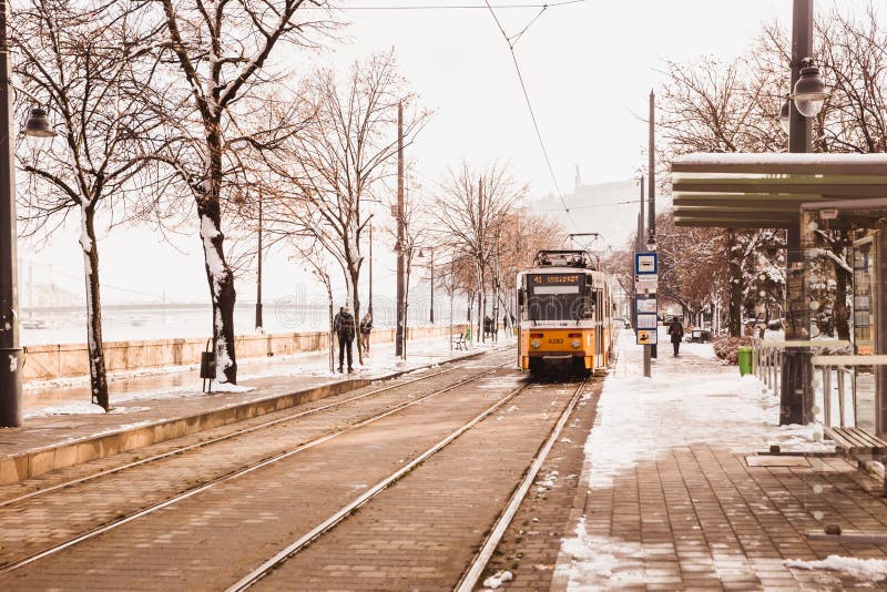 BUDAPEST, HUNGRIA - 16 DE DEZEMBRO DE 2018: Terraplenagem de Danúbio com o bonde amarelo do lado de Buda no inverno em Budapest, fotos de stock BUDAPEST, HUNGRIA - 16 DE DEZEMBRO DE 2018: Terraplenagem de Danúbio com o bonde amarelo do lado de Buda no inverno em Budapest, fotos de stock