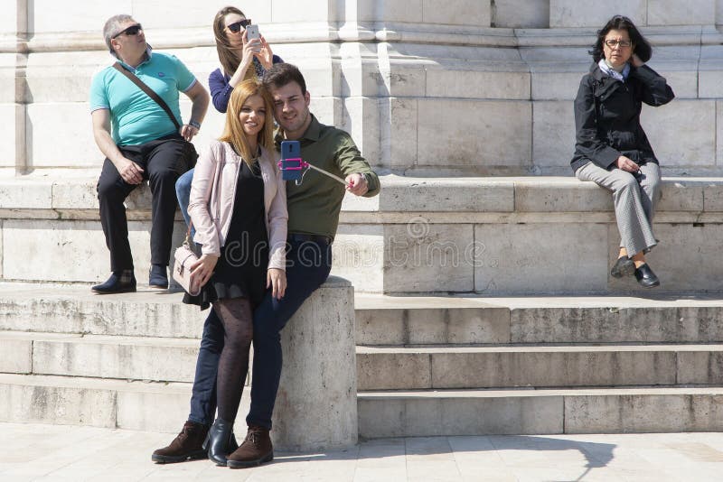 Budapest, Hungría - 8 de abril de 2018: pares que toman el selfie con un teléfono y que hacen caras tontas en la calle fotos de archivo Budapest, Hungría - 8 de abril de 2018: pares que toman el selfie con un teléfono y que hacen caras tontas en la calle fotos de archivo
