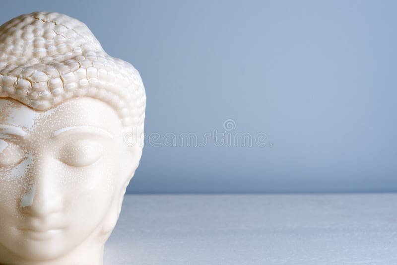 Buddha face. Buddha statue made of white marble with free space for text. Concept of peace, calm and tranquility. Buddhist artifact for Zen style interior decor. Buddha face. Buddha statue made of white marble with free space for text. Concept of peace, calm and tranquility. Buddhist artifact for Zen style interior decor