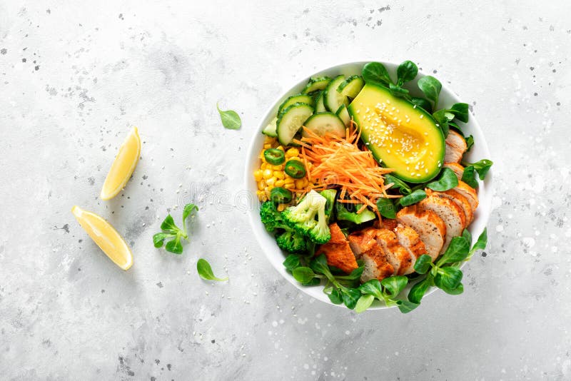 Buddha bowl with grilled chicken breast, avocado and fresh vegetable salad for lunch