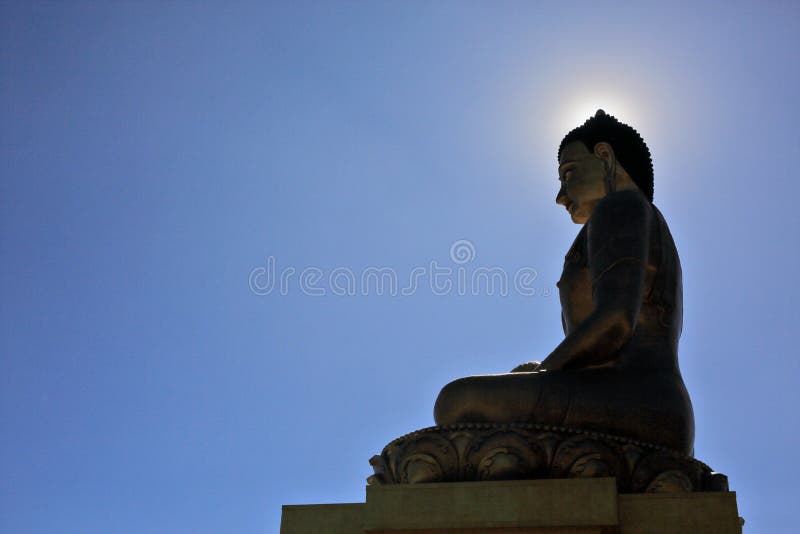 Buddha Dordenma statue silhouette on blue sky background. With sun halo around its head in Thimphu, Bhutan stock photo Buddha Dordenma statue silhouette on blue sky background. With sun halo around its head in Thimphu, Bhutan stock photo