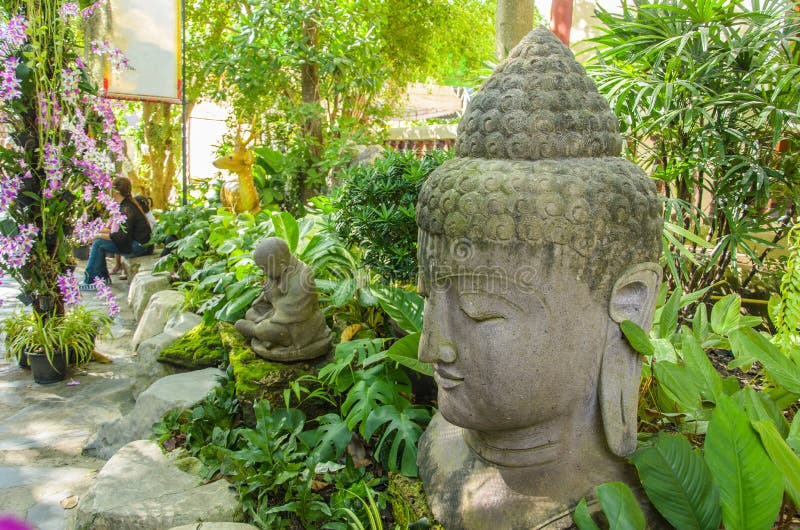 Buddha-Kopfstatue im Garten stockfotografie Buddha-Kopfstatue im Garten stockfotografie