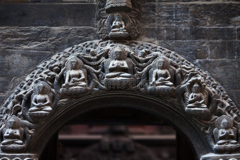 Buddha`s and a bodhisattvas on a stone arch of the Buddhist temp