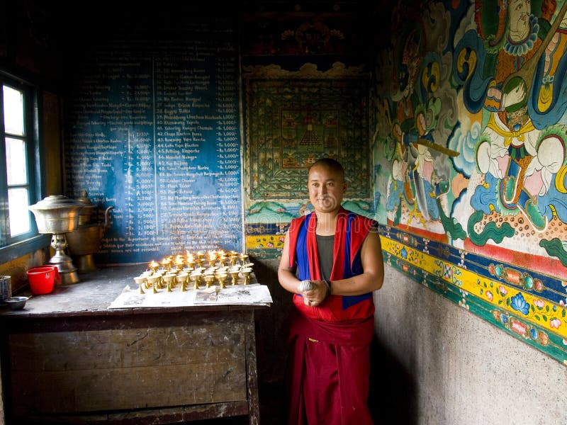 Buddhist Monk Lighting Candles in a Monastery Editorial Stock Photo
