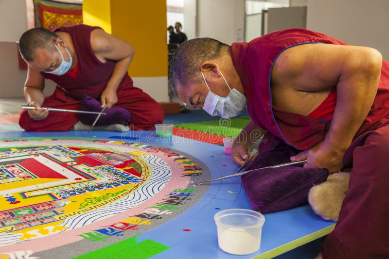 Buddhist monks making mandala from coloured sand