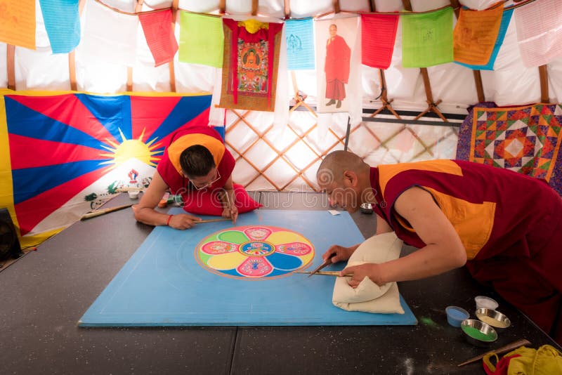 Buddistiska munkar som gör sandmandalaen, denna är en tibetan tradition arkivfoto Buddistiska munkar som gör sandmandalaen, denna är en tibetan tradition arkivfoto