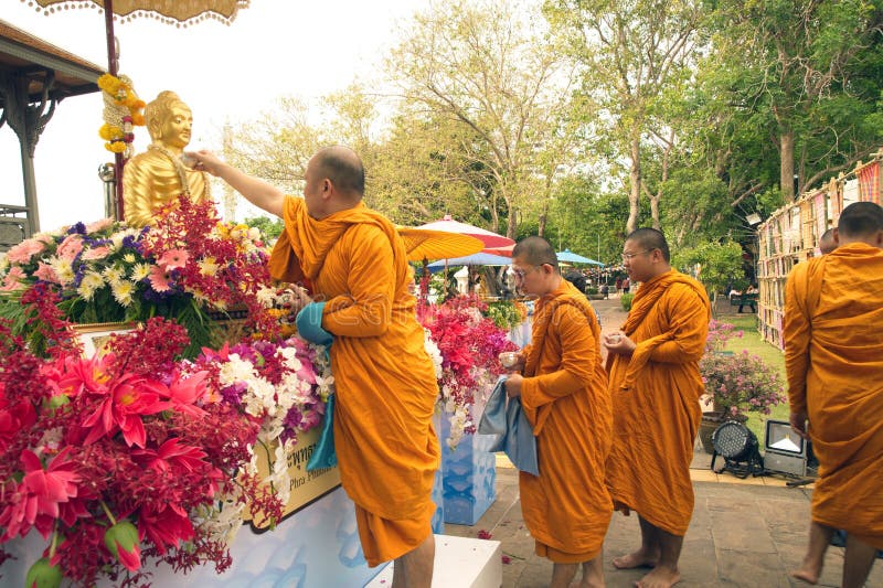 Buddistiska munkar som in strilar vädrat vatten på Buddhabilden royaltyfri bild Buddistiska munkar som in strilar vädrat vatten på Buddhabilden royaltyfri bild