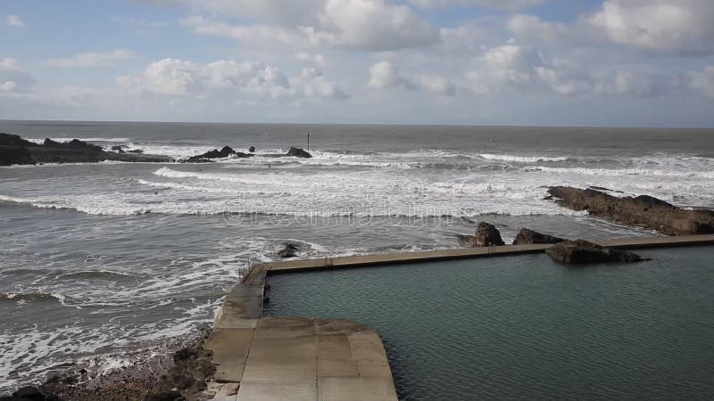 Bude North Cornwall England UK north of Boscastle on a windy day with waves and surfers and popular for surfing pan