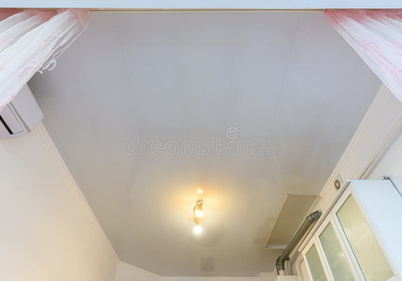 A Budget Ceiling Made of White Plastic Panels in a Spacious Kitchen