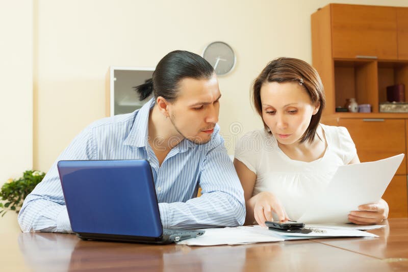 Budget de famille calculateur de couples d'une cinquantaine d'années images libres de droits Budget de famille calculateur de couples d'une cinquantaine d'années images libres de droits