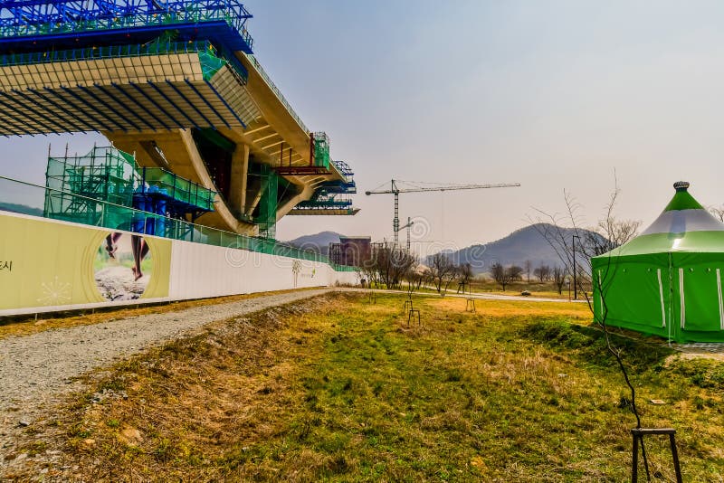 Sejong, South Korea; April 1, 2020: Side view of center section of new bridge under construction through ruraal public park. Sejong, South Korea; April 1, 2020: Side view of center section of new bridge under construction through ruraal public park