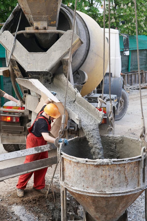 Worker builder controlling concrete filling process at construction site. Worker builder controlling concrete filling process at construction site