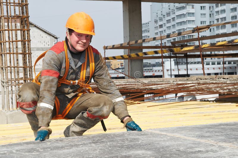 Young builder worker in work wear, helmet and equipment at house building area. Young builder worker in work wear, helmet and equipment at house building area