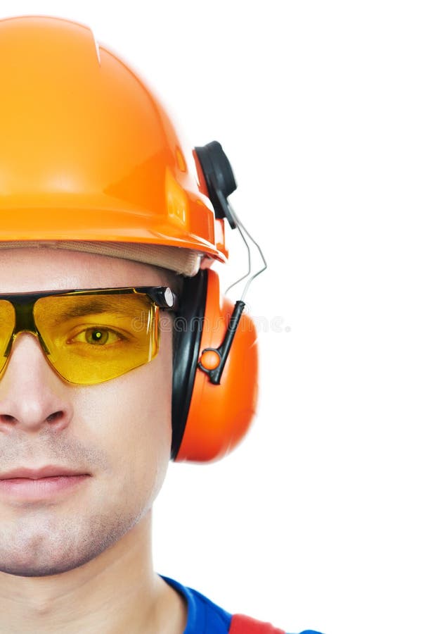 Close-up Portrait of young builder in protective safety equipmant goggles hard hat earmuffs isolated. Close-up Portrait of young builder in protective safety equipmant goggles hard hat earmuffs isolated