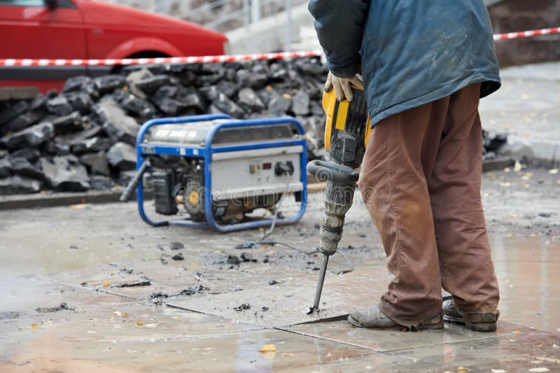 Builder worker with pneumatic hammer drill equipmant breaking asphalt at construction site. Builder worker with pneumatic hammer drill equipmant breaking asphalt at construction site