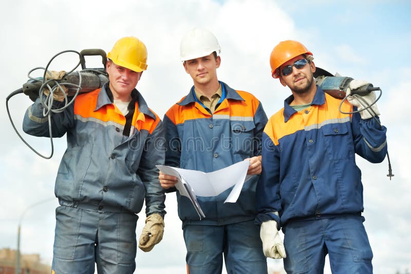 Positive Builder worker with pneumatic hammer drill equipment over blue sky. Positive Builder worker with pneumatic hammer drill equipment over blue sky