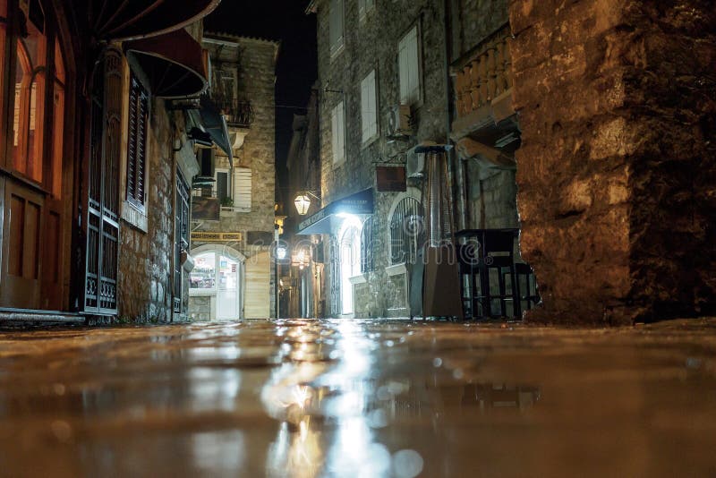 Budva, Черногория - 2-ое февраля 2019 Мощенная булыжником улица старого города загорена вечером светом фонарика стоковые изображения rf Budva, Черногория - 2-ое февраля 2019 Мощенная булыжником улица старого города загорена вечером светом фонарика стоковые изображения rf
