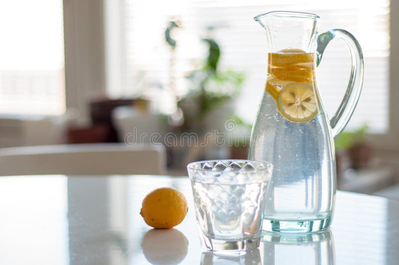 Buen Día! Agua De Limón En Una Jarra O Jarra De Vidrio Y Vertida En Un  Vaso. Agua De Limón Rica En Vitamina C Fresca Para Energía Foto de archivo  - Imagen