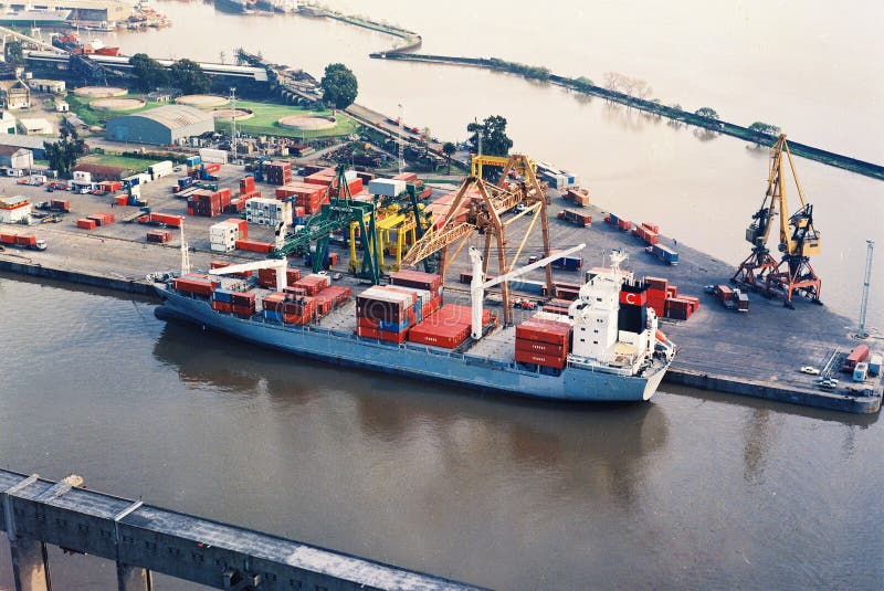 BUENOS AIRES, ARGENTINA - DECEMBER 16, 2012: Cargo ships with shipping containers at a container terminal in Puerto Nuovo, Buenos Aires, Argentina on a overcast weather air viuc maqueira year 2017. BUENOS AIRES, ARGENTINA - DECEMBER 16, 2012: Cargo ships with shipping containers at a container terminal in Puerto Nuovo, Buenos Aires, Argentina on a overcast weather air viuc maqueira year 2017