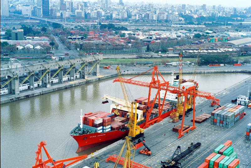 BUENOS AIRES, ARGENTINA - DECEMBER 16, 2012: Cargo ships with shipping containers at a container terminal in Puerto Nuovo, Buenos Aires, Argentina on a overcast weather air viuc maqueira year 2017. BUENOS AIRES, ARGENTINA - DECEMBER 16, 2012: Cargo ships with shipping containers at a container terminal in Puerto Nuovo, Buenos Aires, Argentina on a overcast weather air viuc maqueira year 2017