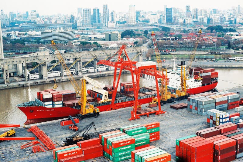 BUENOS AIRES, ARGENTINA - DECEMBER 16, 2012: Cargo ships with shipping containers at a container terminal in Puerto Nuovo, Buenos Aires, Argentina on a overcast weather air viuc maqueira year 2017. BUENOS AIRES, ARGENTINA - DECEMBER 16, 2012: Cargo ships with shipping containers at a container terminal in Puerto Nuovo, Buenos Aires, Argentina on a overcast weather air viuc maqueira year 2017