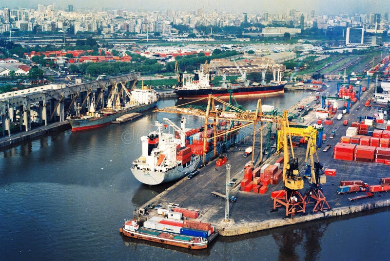 BUENOS AIRES, ARGENTINA - DECEMBER 16, 2012: Cargo ships with shipping containers at a container terminal in Puerto Nuovo, Buenos Aires, Argentina on a overcast weather air viuc maqueira year 2017. BUENOS AIRES, ARGENTINA - DECEMBER 16, 2012: Cargo ships with shipping containers at a container terminal in Puerto Nuovo, Buenos Aires, Argentina on a overcast weather air viuc maqueira year 2017