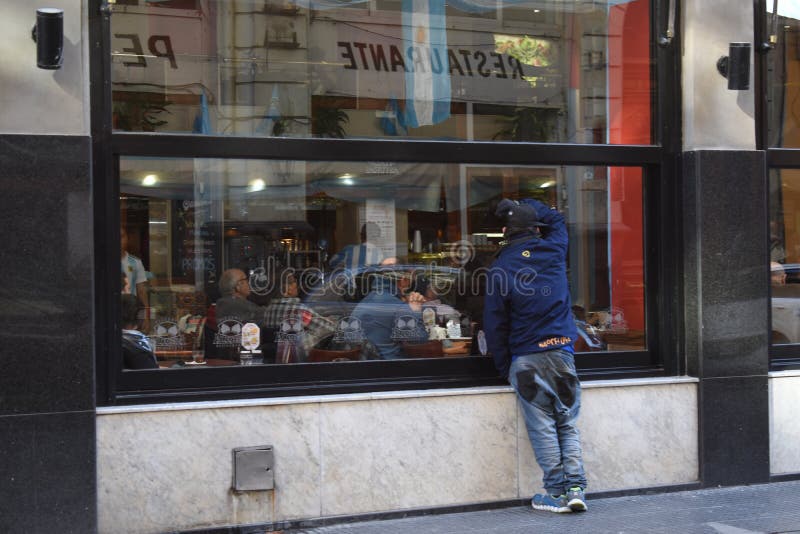 Buenos Aires City, Argentina 16 giugno 2018 Un uomo che guarda fuori dalla finestra di un ristorante una partita di calcio durant immagini stock libere da diritti Buenos Aires City, Argentina 16 giugno 2018 Un uomo che guarda fuori dalla finestra di un ristorante una partita di calcio durant immagini stock libere da diritti