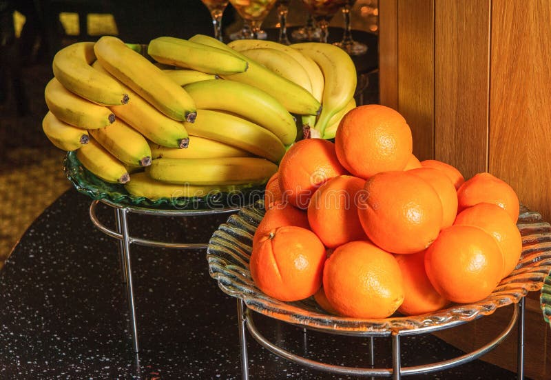 Buffet Table with Fruit Bowls Full of Bananas and Oranges Stock Photo