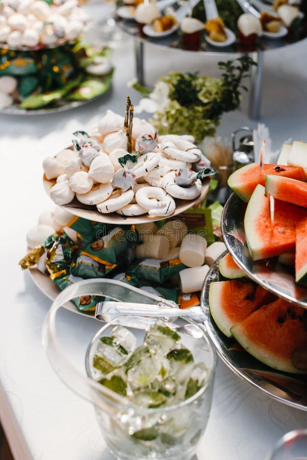 Buffet table with wine and juice, fruits and sweets, snacks and mint ice royalty free stock photo