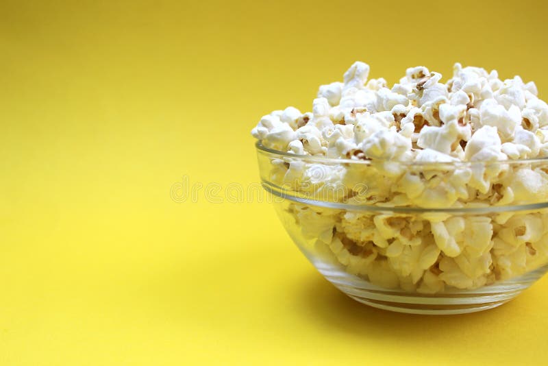 Bugie croccanti salate del popcorn su una lastra di vetro immagini stock libere da diritti