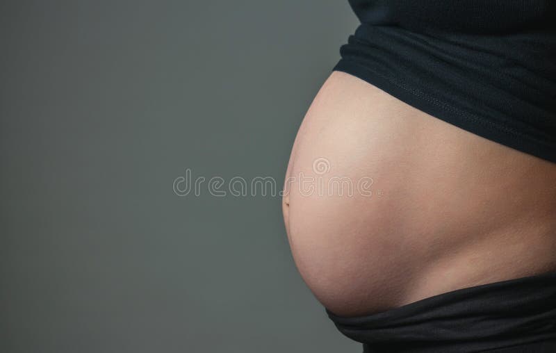 Buik van zwangere vrouw in profiel stock fotografie Buik van zwangere vrouw in profiel stock fotografie