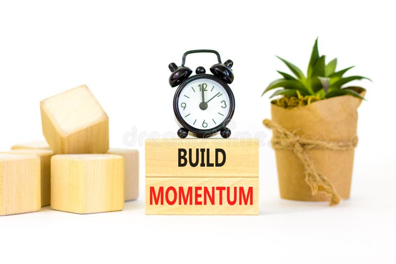 Build momentum symbol. Concept words Build momentum on wooden blocks. Beautiful white table white background. Black alarm clock. royalty free stock photo