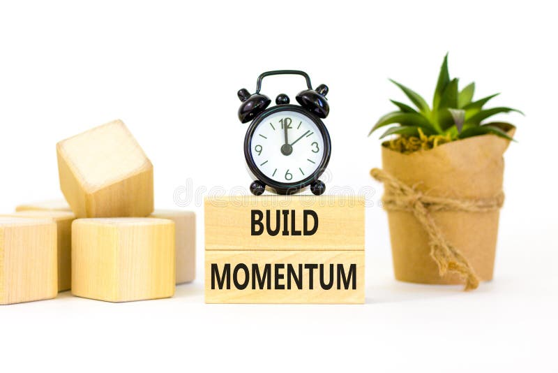 Build momentum symbol. Concept words Build momentum on wooden blocks. Beautiful white table white background. Black alarm clock. royalty free stock photography