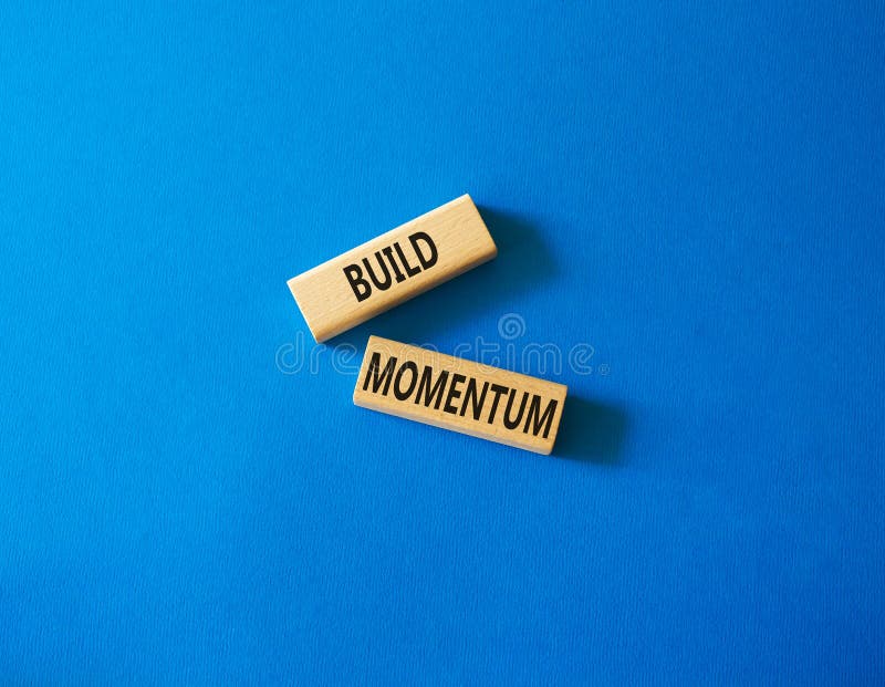 Build momentum symbol. Wooden blocks with words Build momentum. Beautiful blue background. Business and Build momentum concept. royalty free stock photography